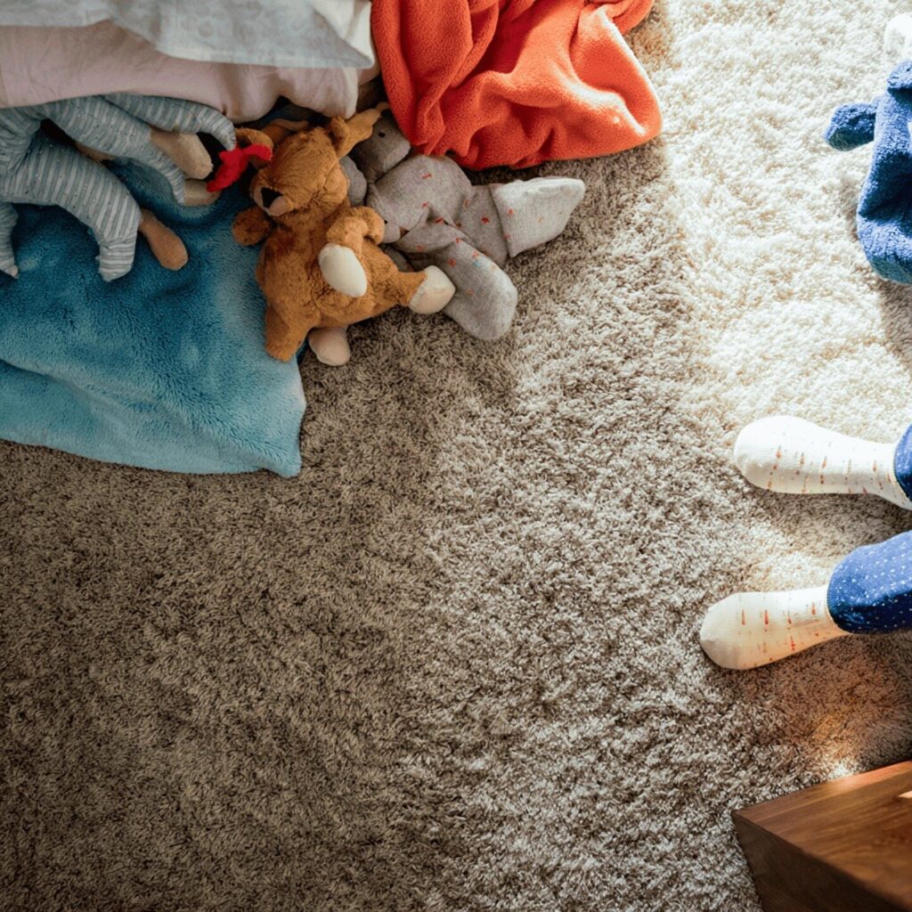 Toys spread on the floor of carpeted kids room