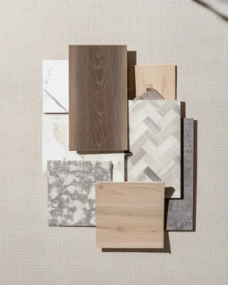 Flat lay arrangement of interior design material samples, including wood, tile, stone, and fabric swatches.